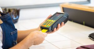 Pagamento com cartão em maquininha de pequeno comércio