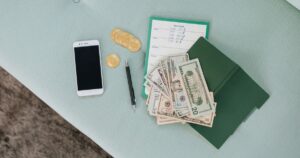 Celular, moedas e dinheiro sobre a mesa
