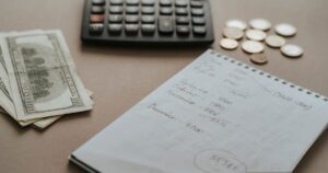 Calculadora, dinheiro e anotações de orçamento sobre a mesa