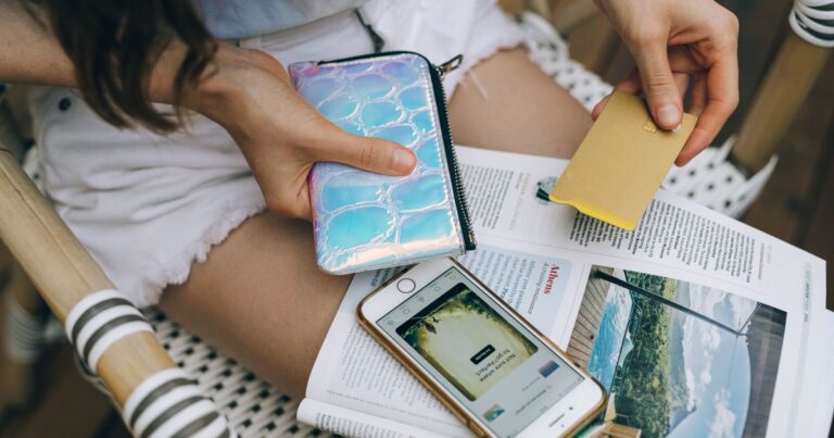 Jovem com celular e cartão de crédito